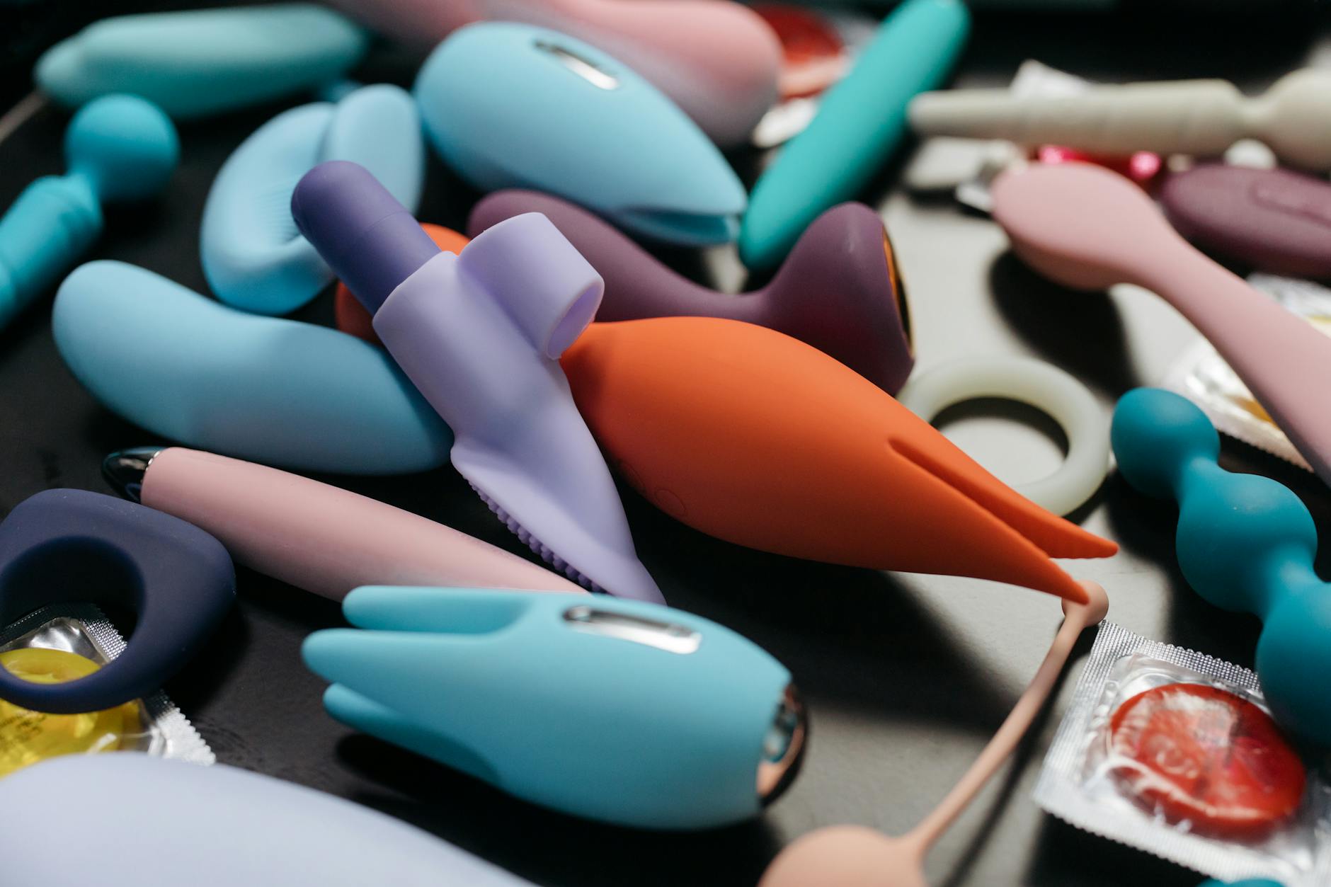 Intimate close-up of hands holding a sleek clitoral vibrator together