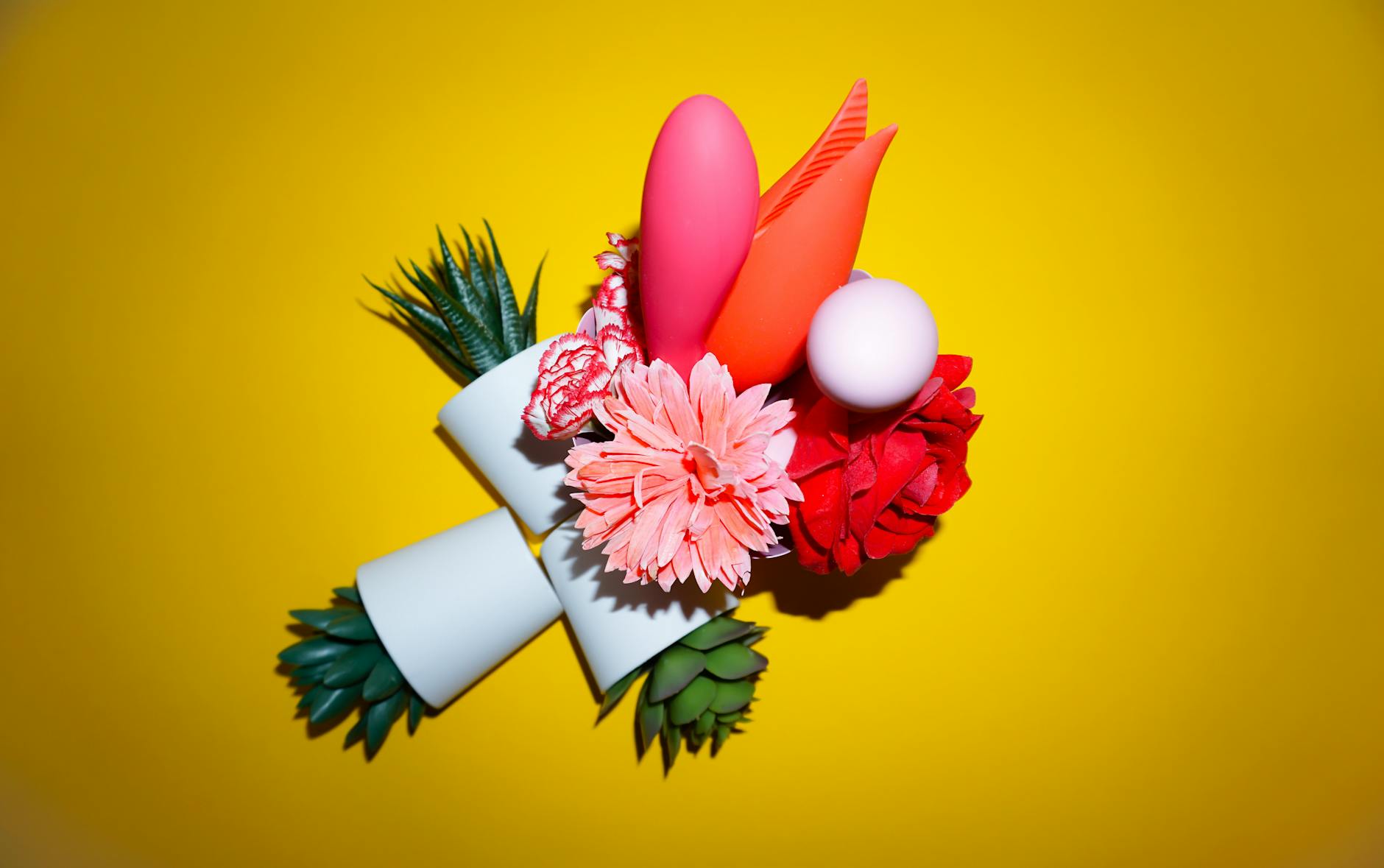 Vibrant collection of colorful clitoral vibrators displayed on a yellow surface